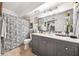 Updated bathroom with gray vanity, large mirror, modern fixtures, and decorative shower curtain at 206 E South St # 3008, Orlando, FL 32801