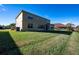 Spacious backyard featuring lush green grass, and the exterior of the home with an AC unit at 207 Black Springs Ln, Winter Garden, FL 34787