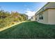 Large backyard featuring lush green grass and the exterior of the home; perfect for outdoor activities at 207 Black Springs Ln, Winter Garden, FL 34787
