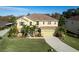 Aerial view of home, landscaping, and manicured lawn with mature palms, green shutters and green garage door at 207 Black Springs Ln, Winter Garden, FL 34787