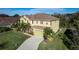 Aerial view of a two-story home featuring a green garage door, mature palms, and a landscaped front yard at 207 Black Springs Ln, Winter Garden, FL 34787