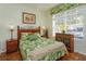 Cozy bedroom featuring tropical-themed bedding, hardwood floors, and a bright window at 2348 Silver Palm, Kissimmee, FL 34747