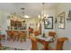 Open dining area with rattan chairs, glass table, a chandelier, and view of kitchen with counter seating at 2348 Silver Palm, Kissimmee, FL 34747