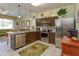 Open kitchen with stainless steel appliances, granite counters, and breakfast bar at 2348 Silver Palm, Kissimmee, FL 34747