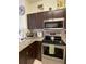 Kitchen featuring granite countertops, stainless steel appliances, and dark wood cabinetry at 2348 Silver Palm, Kissimmee, FL 34747