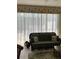 The bright living room features sheer curtains and a comfortable green sofa at 2348 Silver Palm, Kissimmee, FL 34747