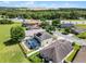 Aerial view showcasing backyard pool, solar panels, landscaping, and neighborhood context near green spaces and roadway at 2411 Sabastian St, Mount Dora, FL 32757