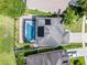 Aerial of a home with a screened pool, solar panels, gray roof, and manicured lawn, showcasing the backyard layout at 2411 Sabastian St, Mount Dora, FL 32757