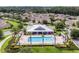 An aerial view of the neighborhood pool and clubhouse, surrounded by mature trees and well-maintained lawns at 2411 Sabastian St, Mount Dora, FL 32757