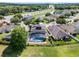 Aerial view of a two-story home featuring a screened pool, solar panels and lush green yard in a suburban neighborhood at 2411 Sabastian St, Mount Dora, FL 32757