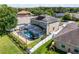 Aerial view of a two-story home featuring a screened pool, solar panels, fenced yard, and lush landscaping at 2411 Sabastian St, Mount Dora, FL 32757
