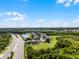 Panoramic aerial view of a vibrant community next to a highway, pond, and lush greenery under a blue sky at 2411 Sabastian St, Mount Dora, FL 32757