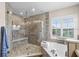 Beautiful bathroom featuring a glass shower, soaking tub, and elegant fixtures at 2411 Sabastian St, Mount Dora, FL 32757