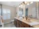 Bathroom featuring dual sinks, decorative mirrors, and a private shower at 2411 Sabastian St, Mount Dora, FL 32757