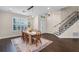 Bright dining room featuring hardwood floors, neutral paint, plantation shutters, and modern chandelier at 2411 Sabastian St, Mount Dora, FL 32757