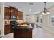 The open kitchen boasts wooden cabinets, black appliances, and a center island overlooking dining at 2411 Sabastian St, Mount Dora, FL 32757