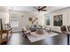 The cozy living room features hardwood floors, a ceiling fan, and neutral wall colors at 2411 Sabastian St, Mount Dora, FL 32757