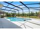 A refreshing screened pool with an attached spa, surrounded by a bright concrete patio, and featuring string lights at 2411 Sabastian St, Mount Dora, FL 32757
