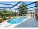 A refreshing screened pool with an attached spa, surrounded by a bright concrete patio, and featuring string lights at 2411 Sabastian St, Mount Dora, FL 32757