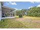 Expansive backyard featuring a screened lanai, lush greenery, and mature trees, perfect for outdoor activities and relaxation at 25057 Riverwalk Dr, Leesburg, FL 34748