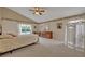 Cozy bedroom with neutral carpeting, vaulted ceiling, and natural light, offering a serene retreat at 25057 Riverwalk Dr, Leesburg, FL 34748