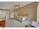 Spacious bedroom with floral wallpaper, neutral carpeting, and a ceiling fan, creating a comfortable atmosphere at 25057 Riverwalk Dr, Leesburg, FL 34748
