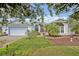 Charming single-story home with lush landscaping, a two-car garage, and an inviting entrance at 25057 Riverwalk Dr, Leesburg, FL 34748