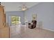 A bright living room with tile floors, a ceiling fan, and sliding glass doors leading to the outdoors at 25057 Riverwalk Dr, Leesburg, FL 34748