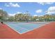 Well-maintained tennis courts with blue and red surfaces, enclosed by a green fence, perfect for sports enthusiasts at 25057 Riverwalk Dr, Leesburg, FL 34748