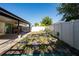 An outdoor backyard features a covered patio, hammock, garden bed, and perimeter fencing at 2790 Monticello Way, Kissimmee, FL 34741