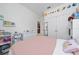 Bright bedroom with decorative wall decals, closet, and an open doorway into another room at 2790 Monticello Way, Kissimmee, FL 34741