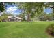 Large backyard featuring mature trees, a well-maintained lawn, and a picturesque view of the home's exterior at 3085 Vest Rd, St Cloud, FL 34772