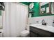 Stylish bathroom with green walls, a modern vanity, and a decorative flower for a vibrant and inviting space at 3085 Vest Rd, St Cloud, FL 34772