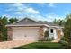 Charming single-story home featuring a two-car garage and beautifully landscaped front yard, blending stone and siding accents at 319 Sequoia Dr, Lake Wales, FL 33859