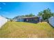 Spacious backyard featuring a well-maintained lawn, white fencing, and screened patio, perfect for outdoor living at 329 Drake Elm Dr, Kissimmee, FL 34743