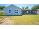Spacious backyard featuring a well-maintained lawn, and view of the home's rear elevation and screened patio at 329 Drake Elm Dr, Kissimmee, FL 34743