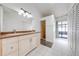 Bathroom with a double vanity, tiled floors, walk-in shower, and a sliding glass door to a sunroom at 329 Drake Elm Dr, Kissimmee, FL 34743