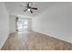 Bedroom with wood-look flooring, a ceiling fan, and a large window offering plenty of natural light at 329 Drake Elm Dr, Kissimmee, FL 34743