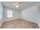 Bright bedroom with wood-look floors, a ceiling fan, and a window that provides ample natural light at 329 Drake Elm Dr, Kissimmee, FL 34743