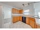 Kitchen with oak cabinets, black appliances, tile flooring and track lighting above the sink at 329 Drake Elm Dr, Kissimmee, FL 34743