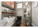Modern bathroom featuring unique silver tiled walls, a glass sink, and a sleek black toilet at 356 S Osceola Ave # 19, Orlando, FL 32801