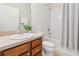 Bright bathroom with a single sink vanity, toilet, and bathtub with a shower featuring bright, neutral finishes at 3566 Southern Cross Loop, Kissimmee, FL 34744