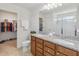 A bathroom with a double sink vanity featuring granite countertops, a toilet, and a walk in closet at 3566 Southern Cross Loop, Kissimmee, FL 34744