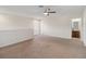 Large bonus room with tan carpet, fan, window, and bathroom entrance at 3566 Southern Cross Loop, Kissimmee, FL 34744