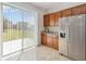 Kitchen with stainless steel refrigerator, cabinets, and sliding glass doors to the backyard at 3566 Southern Cross Loop, Kissimmee, FL 34744
