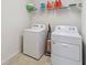 Functional laundry area with modern washer, dryer, and convenient overhead shelving at 3566 Southern Cross Loop, Kissimmee, FL 34744
