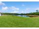 A beautifully landscaped backyard view with a tranquil lake at 4002 Scarlet Branch Rd, Orlando, FL 32824