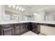 Bathroom vanity with dark cabinets, white countertop, and large mirrors at 4002 Scarlet Branch Rd, Orlando, FL 32824