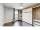 Neutral bedroom featuring a Murphy bed, closet and dark floors, perfect for flexible living and space-saving solutions at 4002 Scarlet Branch Rd, Orlando, FL 32824