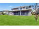 Back exterior view showing lush green lawn and a screened in patio area at 4002 Scarlet Branch Rd, Orlando, FL 32824
